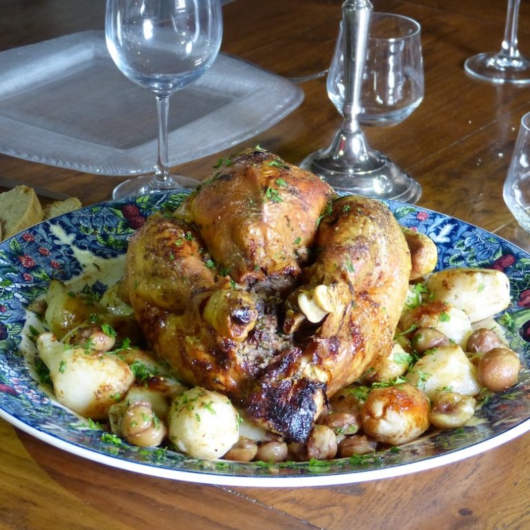 Dinde-aux-marrons-les-causeries-culinaires-recette-fait-maison-boutique-saveur-histoire Photo de la dinde farcie aux marronx posée sur un lit de châtaignes et de topinambours dorés au four.