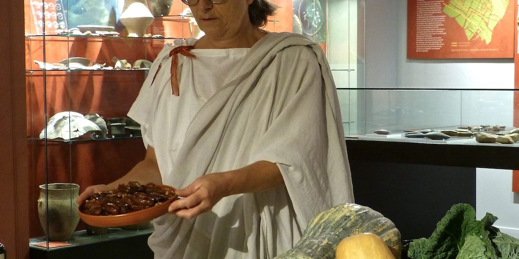 Photo de Sylvie dans le musée présentant des dattes au miel.