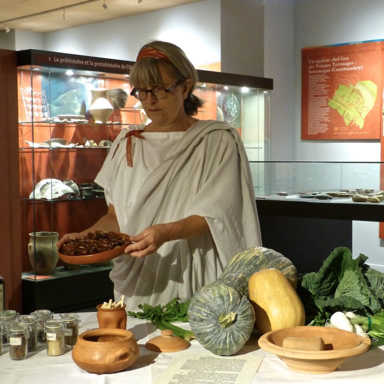 Cuisinière-romains-les-causeries-culinaires-recettes-histoire-cuisine Photo de Sylvie dans le musée présentant des dattes au miel.