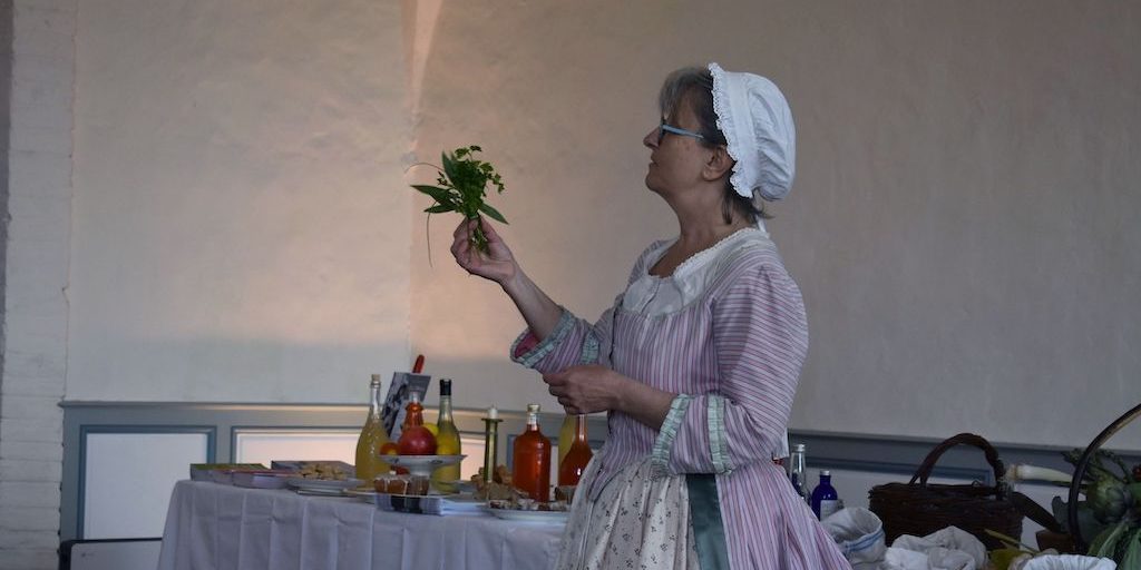 L'animatrice en costume montrant le bouquet garni du XVIIIe siècle.