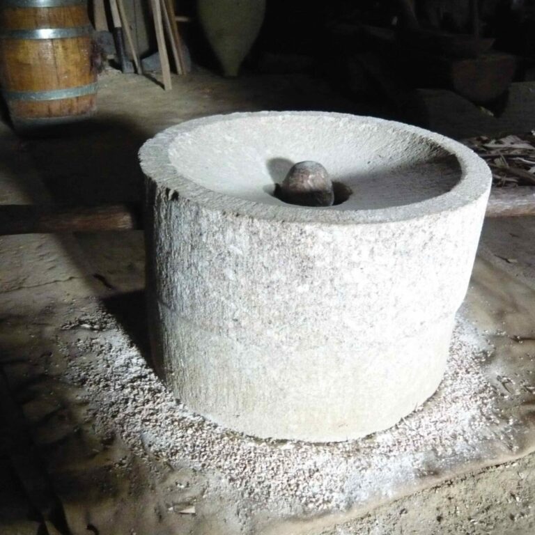 meule-rotative-reproduction-village-gaulois-saint-julien-Haute-Garonne-es-causeries-culinaires-histoire-cours-cuisine-recettes photo d'une meule de pierre en face similé